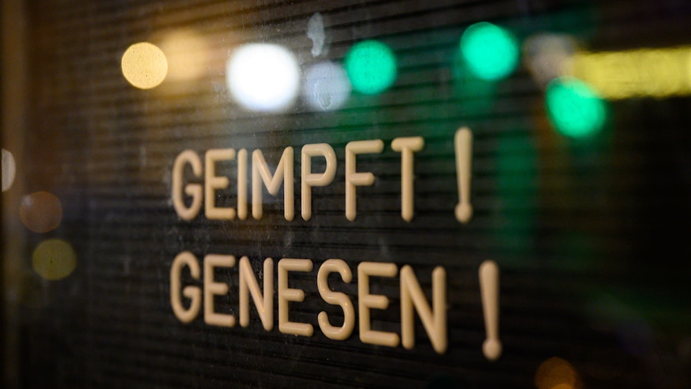 Auf dem Symbolfoto (aufgenommen am 6. November 2021) ist ein Schaukasten zu sehen, in welchem ein Schild mit der Aufschrift „Geimpft! Genesen!“ steht.