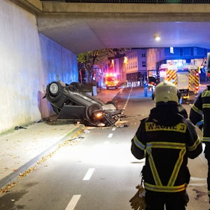 Einsatzkräfte sichern die Unfallstelle in Wuppertal. Eine 63-jährige Solingerin ist mit ihrem Cabrio sechs Meter tief von einer Brücke gestürzt und schwer verletzt worden.