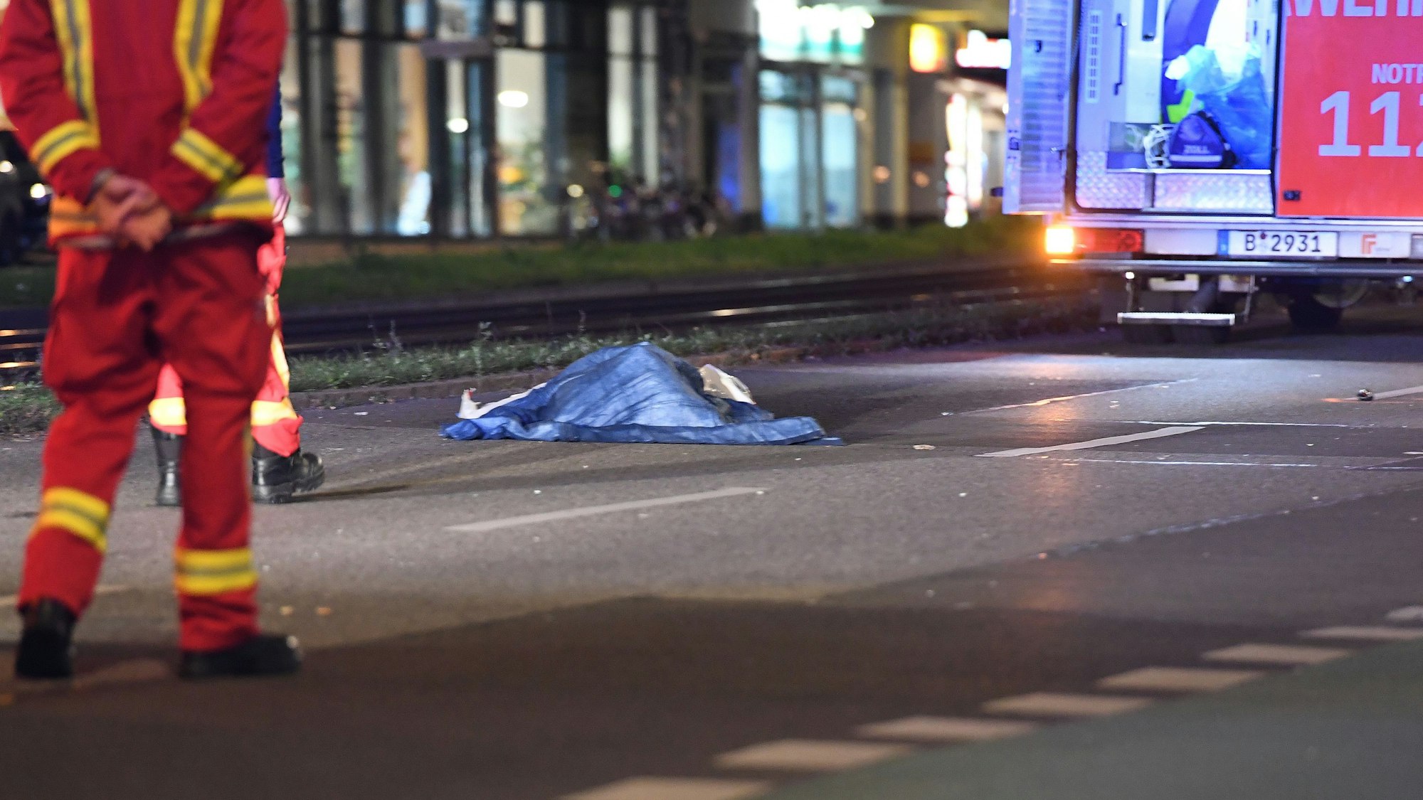 In Berlin wurde ein Mann von einem Auto überrollt. Auf dem Symbolfoto (aufgenommen am 19. Oktober 2021) ist eine Unfallstelleauf der Greifswalder Straße zu sehen. Man erkennt einen Rettungswagen, Rettungskräfte und ein mit Tüchern abgedecktes Unfallopfer.
