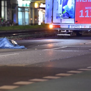In Berlin wurde ein Mann von einem Auto überrollt. Auf dem Symbolfoto (aufgenommen am 19. Oktober 2021) ist eine Unfallstelle auf der Greifswalder Straße zu sehen. Man erkennt einen Rettungswagen, Rettungskräfte und ein mit Tüchern abgedecktes Unfallopfer.