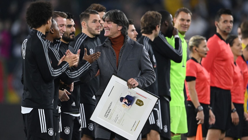 El ex entrenador de la selección nacional Yogi Loew (centro) agradece a los jugadores después de recibir un certificado.