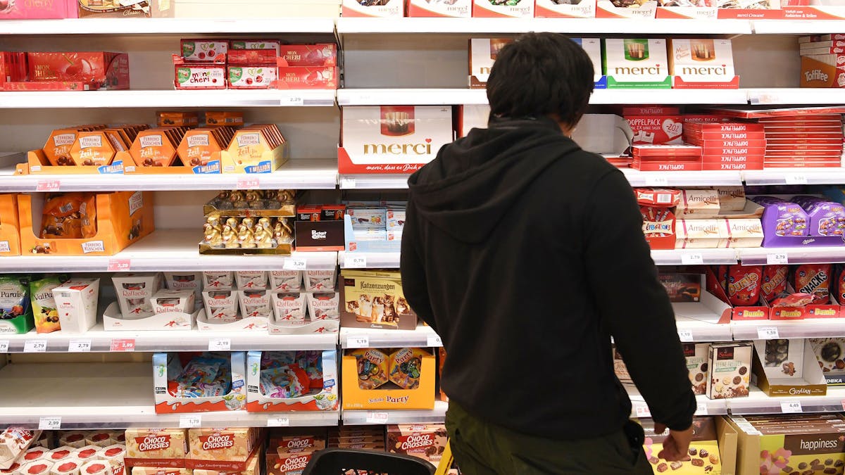 Auf dem Symbolfoto (aufgenommen am 29. Oktober 2018) ist ein Mann vor einem Regal voller Süßigkeiten im Supermarkt zu sehen.