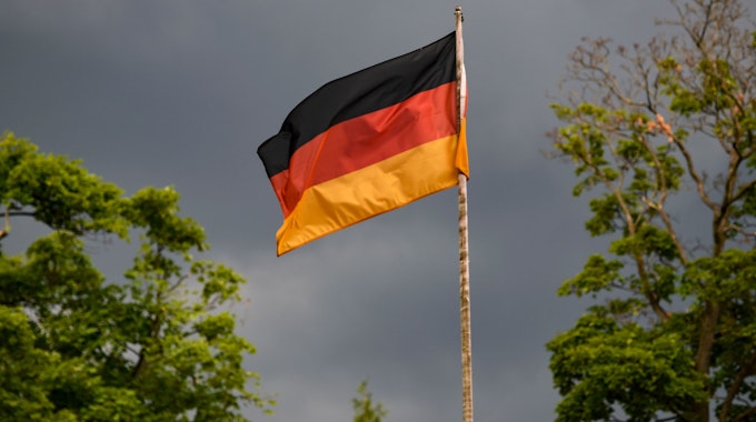 Die deutsche Flagge weht vor dunklen Wolken im Wind. Heute ist das Spiel der deutschen Mannschaft gegen England im Achtelfinale. +++ dpa-Bildfunk +++