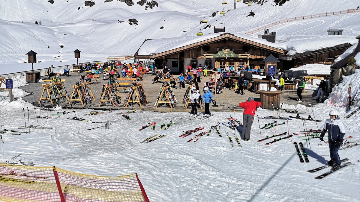 Auf dem Foto (aufgenommen am 31. März 2021) sieht man Skifahrer in Österreich auf der Terrasse einer geschlossenen Skihütte sitzen.&nbsp;
