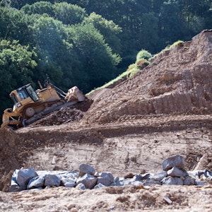 Eine Planierraupe arbeitet an dem vom Hochwasser beschädigten Damm der Steinbachtalsperre.