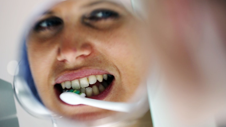 Auf dem Symbolfoto (aufgenommen am 11. März 2013) putzt sich eine Frau mit einer elektrischen Zahnbürste die Zähne.