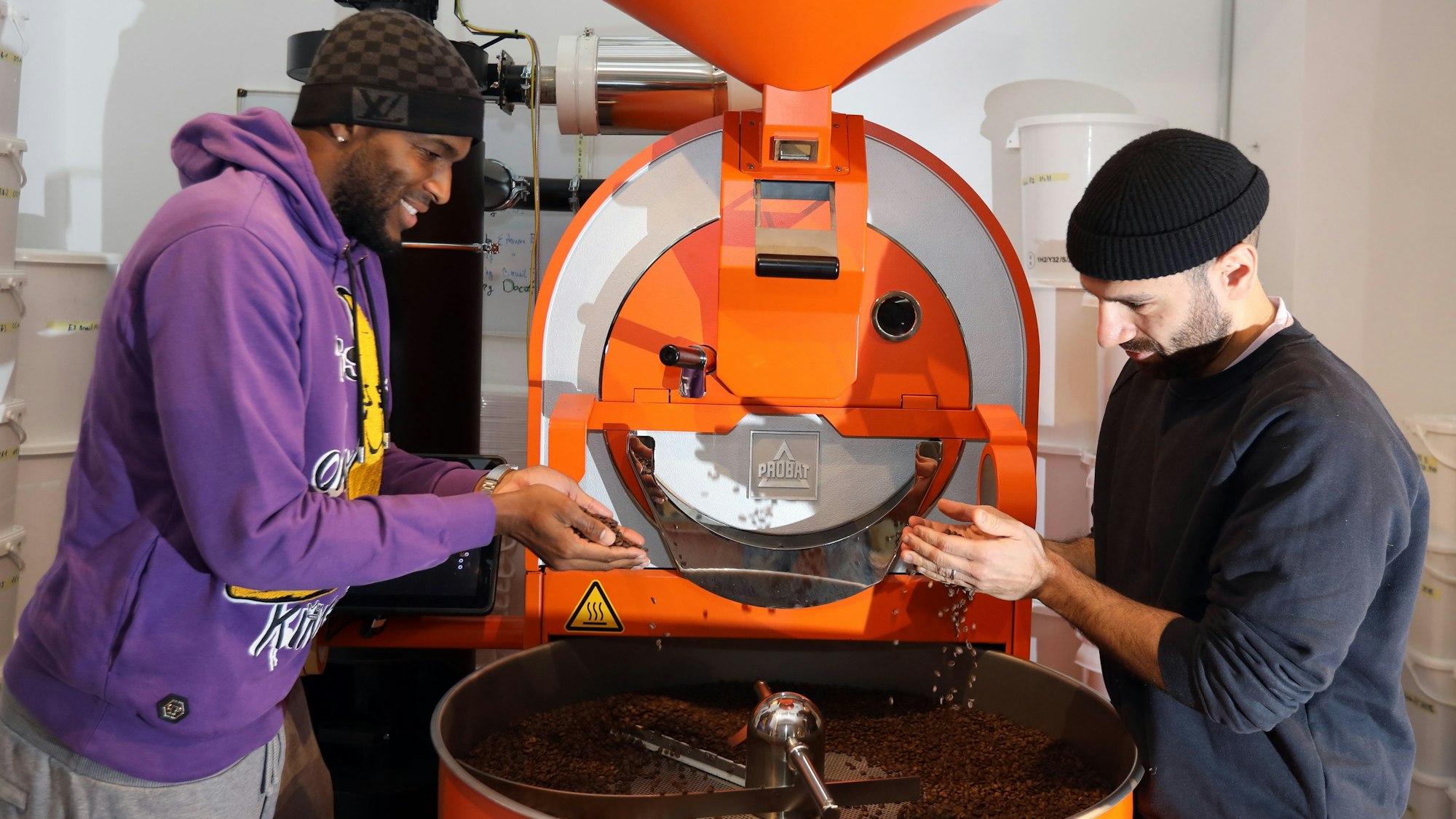 Anthony Modeste und Rafet Aydogdu stehen bei Kaffeesaurus an der Röst-Maschine.