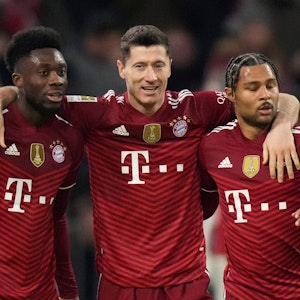 Bayern's Robert Lewandowski jubelt mit Alphonso Davies (l.) und Serge Gnabry (r.).