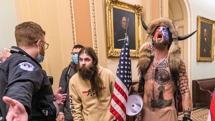 Bilder, die um die Welt gingen: Trump-Anhänger stürmen am 6. Januar das Kapitol in Washington. Jacob Anthony Chansley, der „QAnon-Schamane“ mit der Büffelhorn-Mütze (rechts), war ein Gesicht des Sturms. Er wurde nun verurteilt.