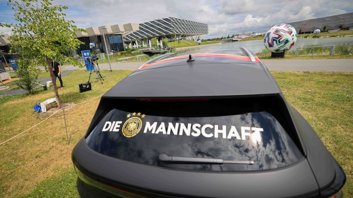 Der Schriftzug „Die Mannschaft“ klebt auf der Heckscheibe eines Volkswagen ID.4 im Bereich des DFB-Medienzentrums auf dem Gelände von Adidas. 