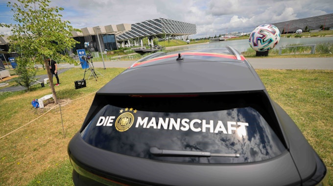Der Schriftzug „Die Mannschaft“ klebt auf der Heckscheibe eines Volkswagen ID.4 im Bereich des DFB-Medienzentrums auf dem Gelände von Adidas.