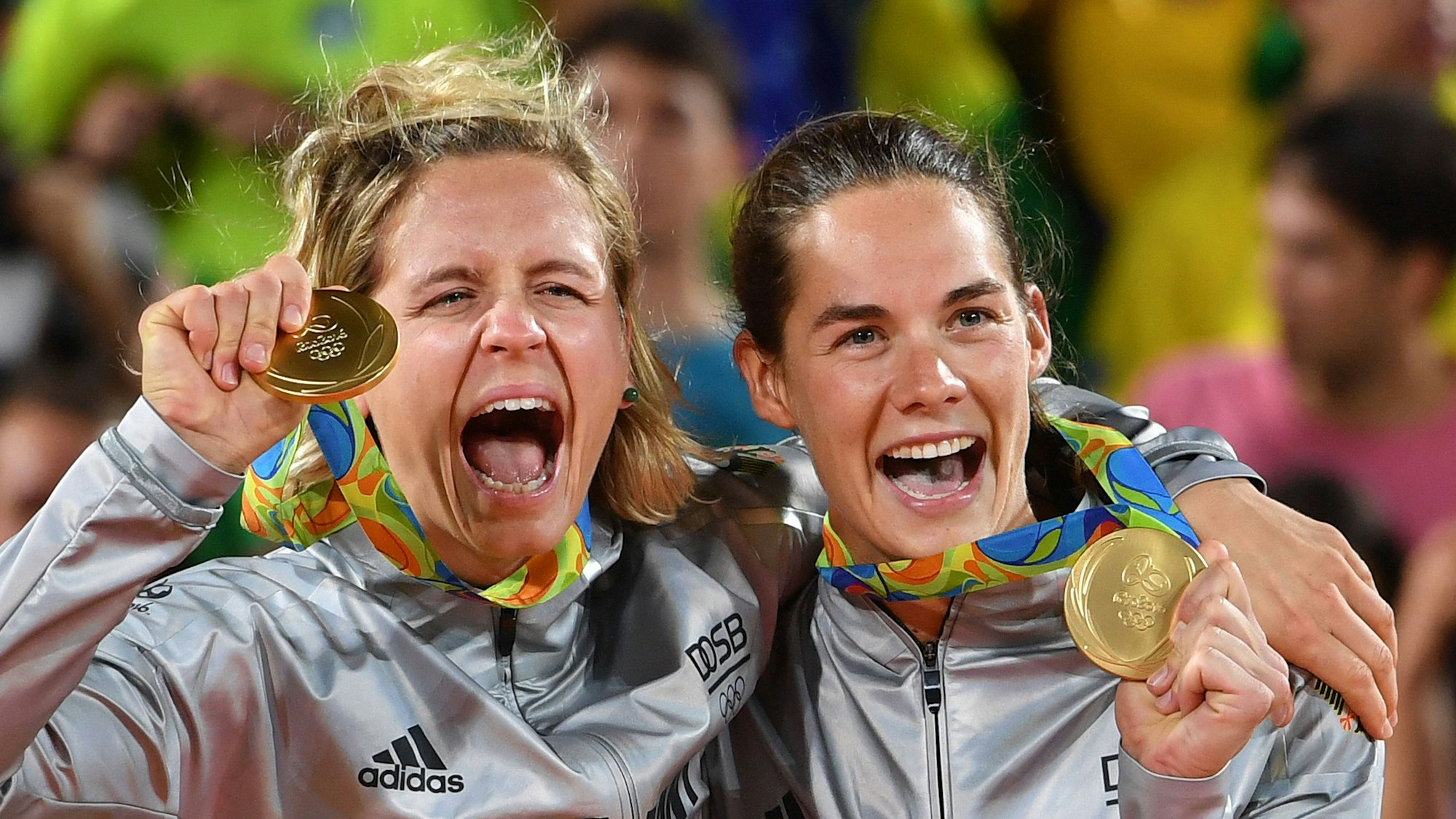 Laura Ludwig und Kira Walkenhorst jubeln mit der Olympischen Goldmedaille.