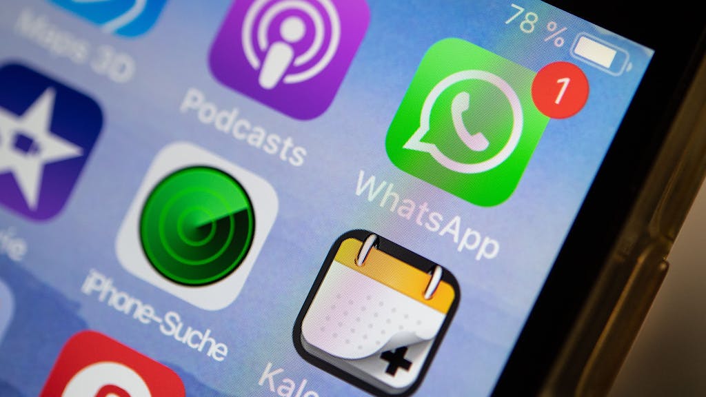 Das Logo der Messenger-App WhatsApp ist auf dem Display eines iPhones zu sehen.