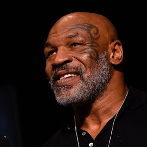 Mike Tyson sitzt bei einem Boxkampf auf der Tribüne