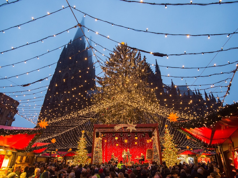 Personen hören sich am 21.12.2017 auf dem Weihnachtsmarkt am Kölner Dom (Nordrhein-Westfalen) eine musikalische Darbietung an. Foto: Rainer Jensen/dpa ++ +++ dpa-Bildfunk +++