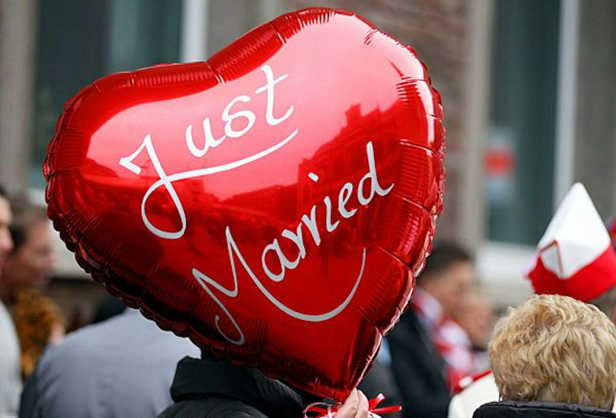 Eine Frau hält am 11.11.2011 in Köln vor dem Rathaus einen Ballon mit der Aufschrift "Just Married" in der Hand.