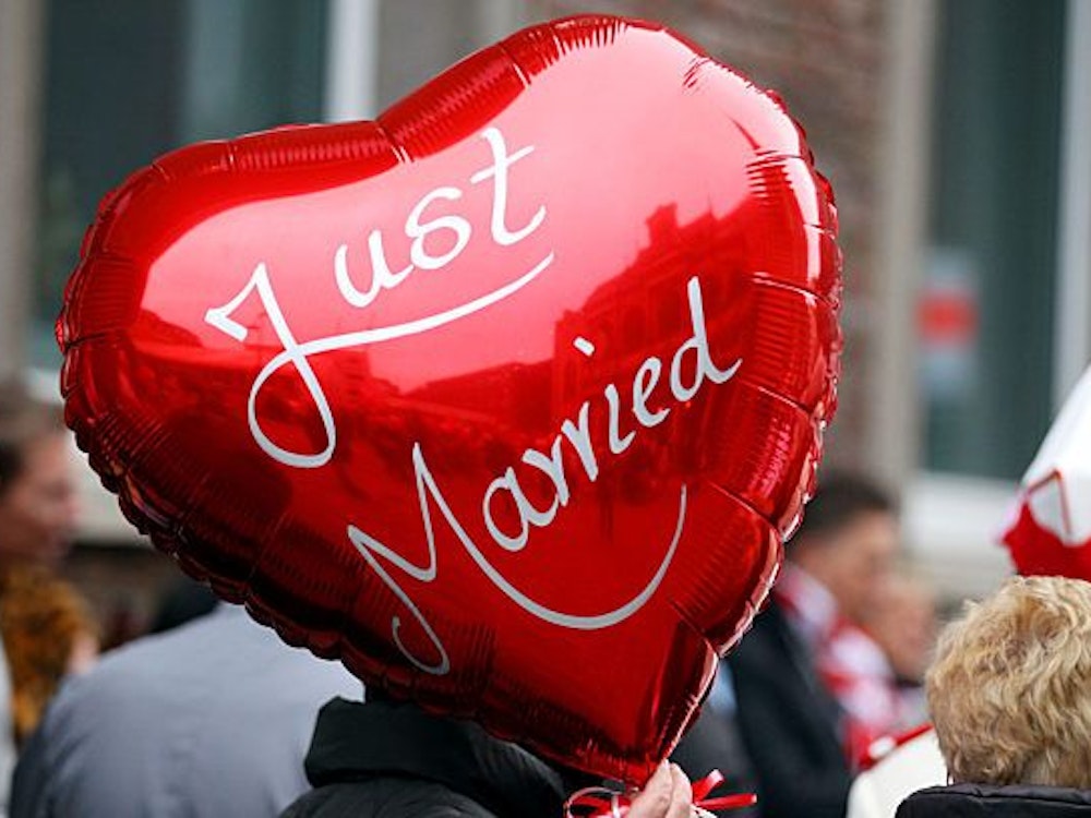 Eine Frau einen Ballon mit der Aufschrift "Just Married" in der Hand.