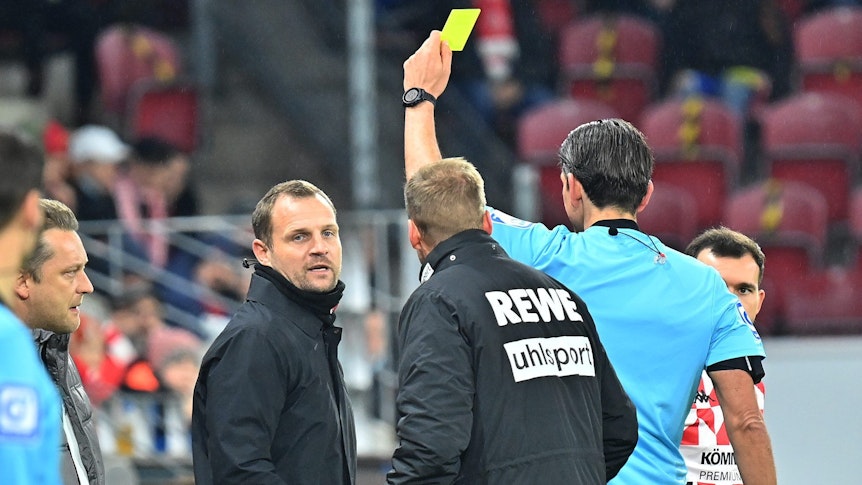 Schiedsrichter Deniz Aytekin zeigt dem Mainzer Trainer Bo Svensson die Gelbe Karte.