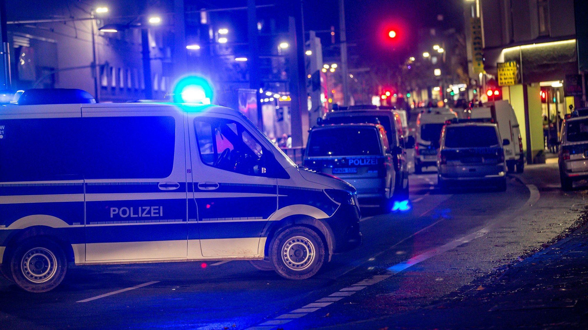 Das Symbolfoto, aufgenommen am 21. November 2021 in Dortmund, stellt ein Polizeiauto mit blinkendem Blaulicht auf einer Hauptstraße bei Nacht dar.