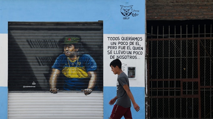 Ein Fußgänger schreitet an einem Gemälde von Diego Maradona vorbei.