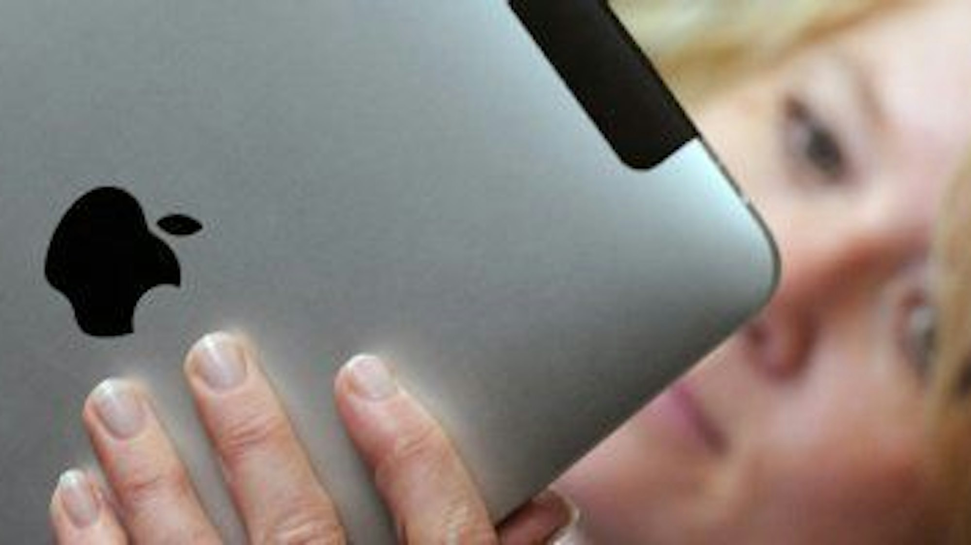 Eine Frau hält ein iPad in der Hand.