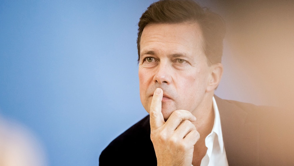 Steffen Seibert, Regierungssprecher, hält beim Tag der offenen Tür der Bundesregierung in der Bundespressekonferenz den Zeigefinger vor den Mund.