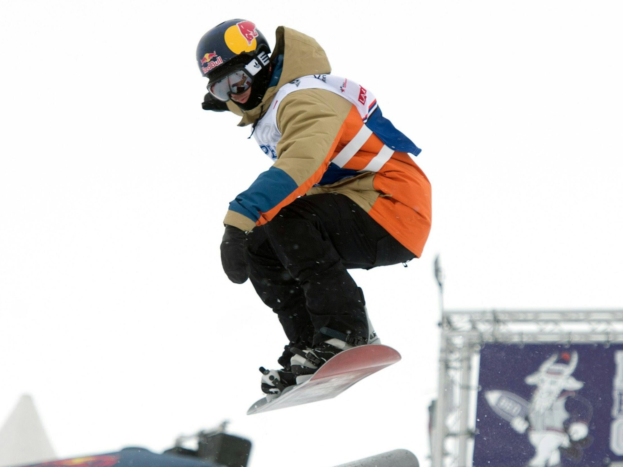 Marko Grilc springt mit seinem Snowboard über eine Schanze.