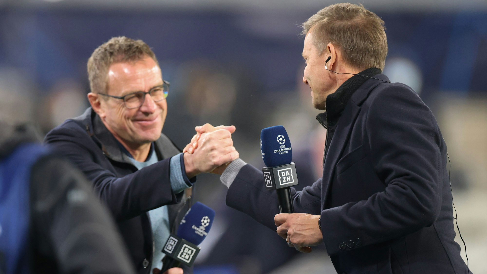 Leipzigs Trainer Jesse Marsch (r) und Leipzigs ehemaliger Trainer Ralf Rangnick schütteln nach einem Interview die Hand.