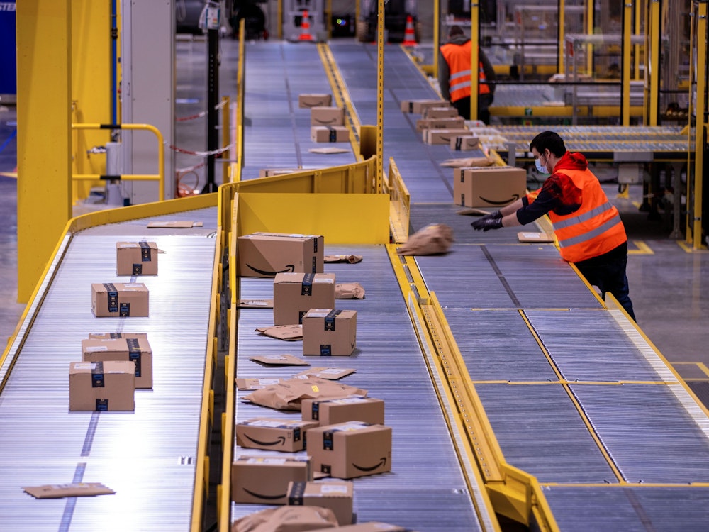 Ein Mitarbeiter sortiert an einem Transportband Paketsendungen im neuen Verteilzentrum des Online-Händlers Amazon.