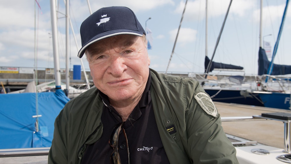 Schauspieler Fritz Wepper sitz mit einer Angel auf einem Angelboot im Hafen.