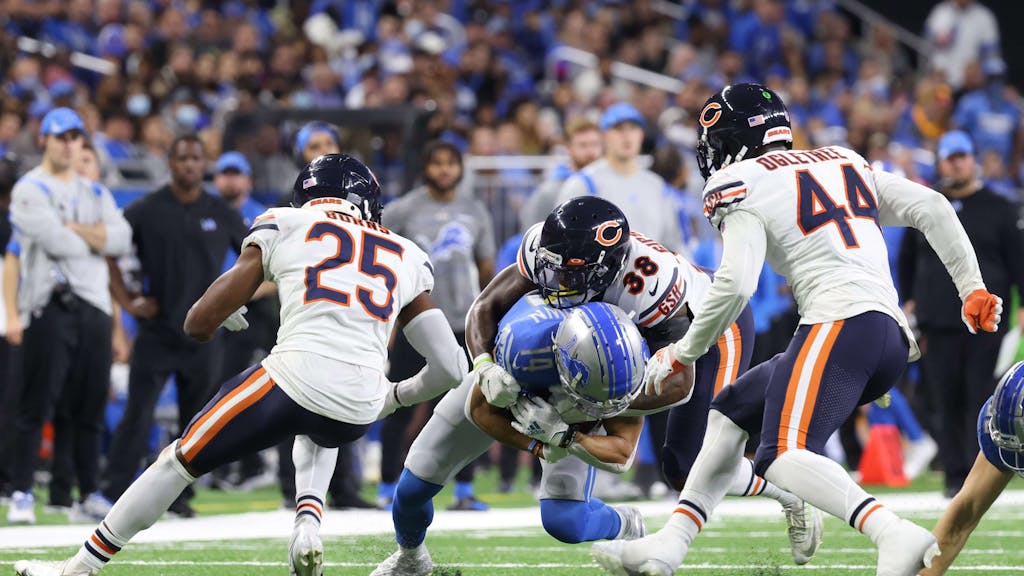 DETROIT, MICHIGAN - NOVEMBER 25: Amon-Ra St. Brown #14 of the Detroit Lions rushes against Tashaun Gipson #38 of the Chicago Bears at Ford Field on November 25, 2021 in Detroit, Michigan.   Leon Halip/Getty Images/AFP
== FOR NEWSPAPERS, INTERNET, TELCOS & TELEVISION USE ONLY ==