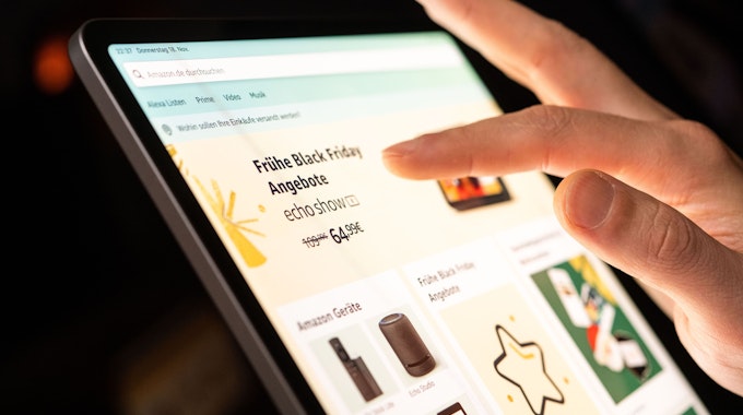 Eine Person schaut sich die Black Friday Angebote auf der Online-Shopping-Seite von Amazon auf seinem Tablet-Computer an.