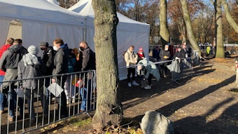 Menschen warten vor dem Impf-Zelt am Kölner Rhein-Energie-Stadion