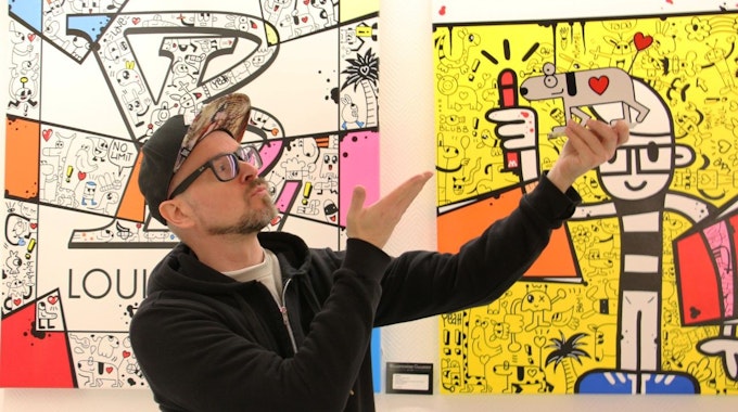 Künstler Honk vor einem seiner Bilder bei der Ausstellung am 26.11.
