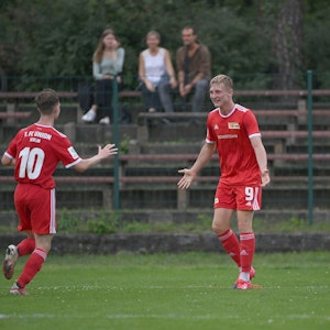 Zwei Jugendspieler von Union Berlin laufen aufeinander zu, um zu jubeln.
