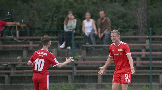 Zwei Jugendspieler von Union Berlin laufen aufeinander zu, um zu jubeln.