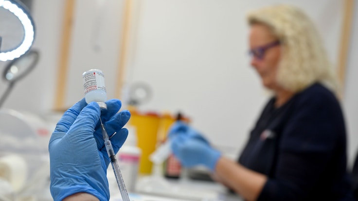 Eine medizinische Fachangestellte zieht am 25. November 2021 in einer Kabine in einem Impfzentrum eine Spritze mit dem Impfstoff Moderna auf.