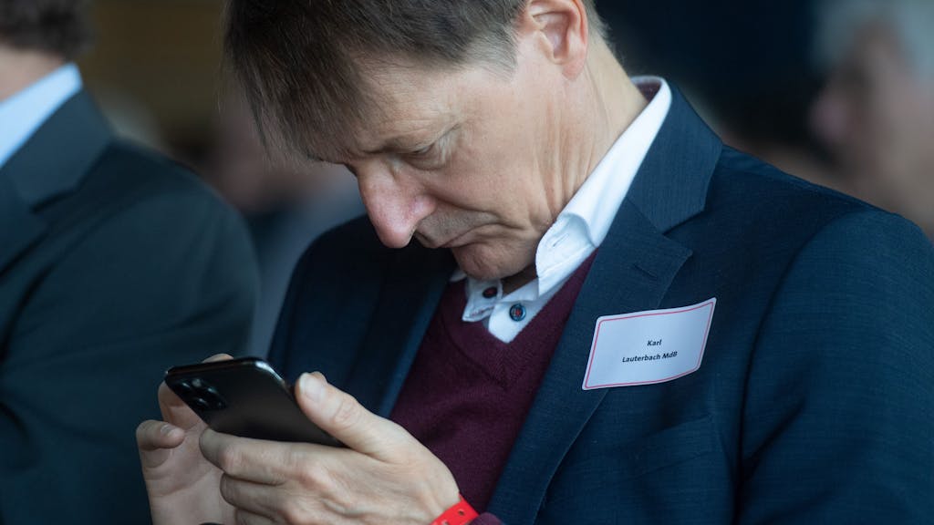 Karl Lauterbach, Gesundheitsexperte der SPD, schaut beim Empfang zum 75. Jubiläum der SPD-Fraktion Nordrhein-Westfalen auf sein Smartphone.&nbsp;