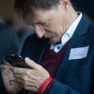 Karl Lauterbach schaut auf sein Smartphone
