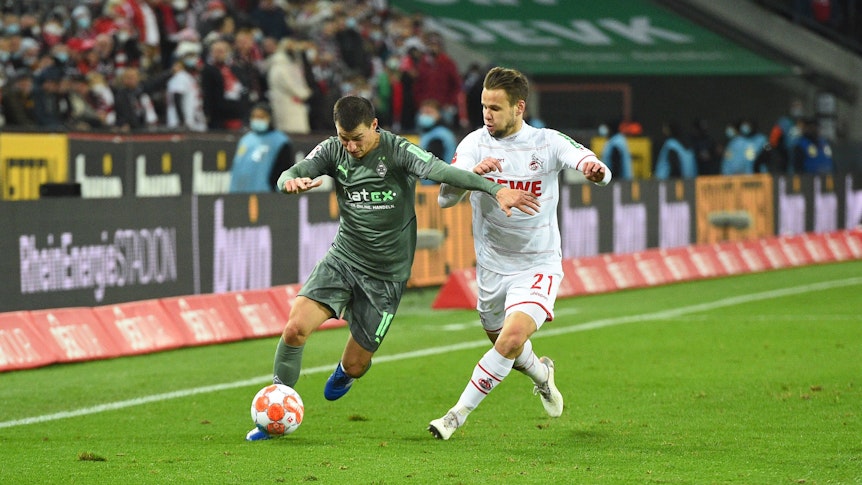 Stefan Lainer (l.) von Borussia Mönchengladbach mit dem Ball am Fuß, versucht Louis Schaub (r.) vom 1. FC Köln am 27. November 2021 zurückzuhalten.