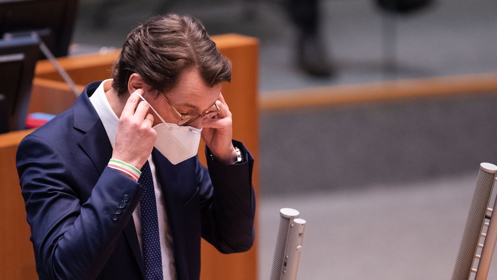 Hendrik Wüst (CDU), Ministerpräsident von Nordrhein-Westfalen, setzt nach seiner Rede im Landtag seine FFP2-Maske auf.