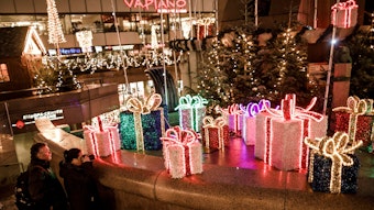 Besucher gehen an Weihnachtsdekorationen auf dem Weihnachtsmarkt am Breitscheidplatz vorbei.