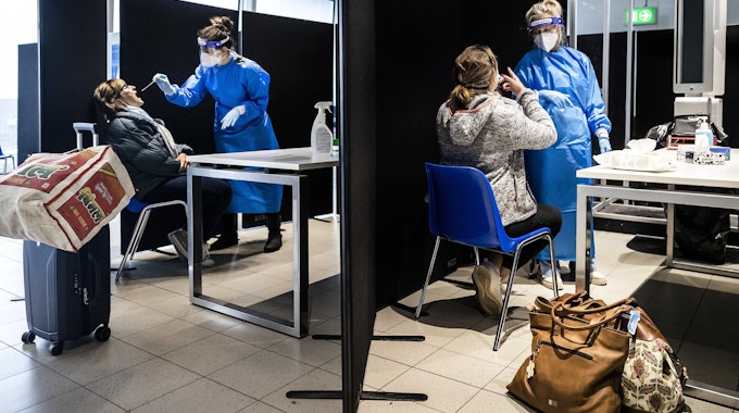 Reisende aus Südafrika werden am 30. November bei der Ankunft am Flughafen Schiphol (Niederlande) in einer eigens angelegten Teststraße auf das Coronavirus getestet. Die Sorge vor der Omikron-Variante des Coronavirus steigt weltweit, nun hat ein Impfstoff-Hersteller Bedenken geäußert.