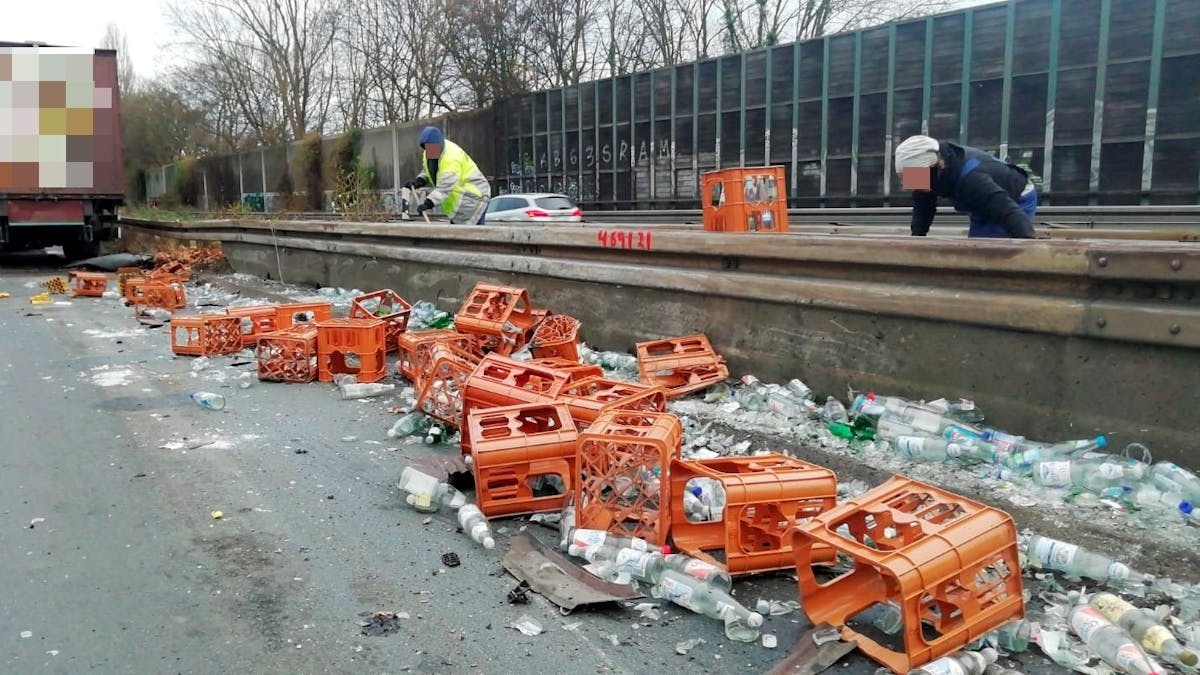 Nach einem Unfall auf der A555 liegen zahlreiche Getränkekisten und Flaschen an der Leitplanke.&nbsp;