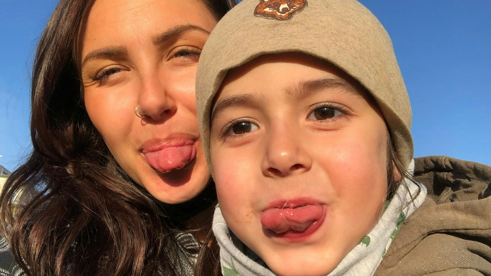 Derya und ihr Sohn Kian strecken dem Fotografen die Zunge raus.