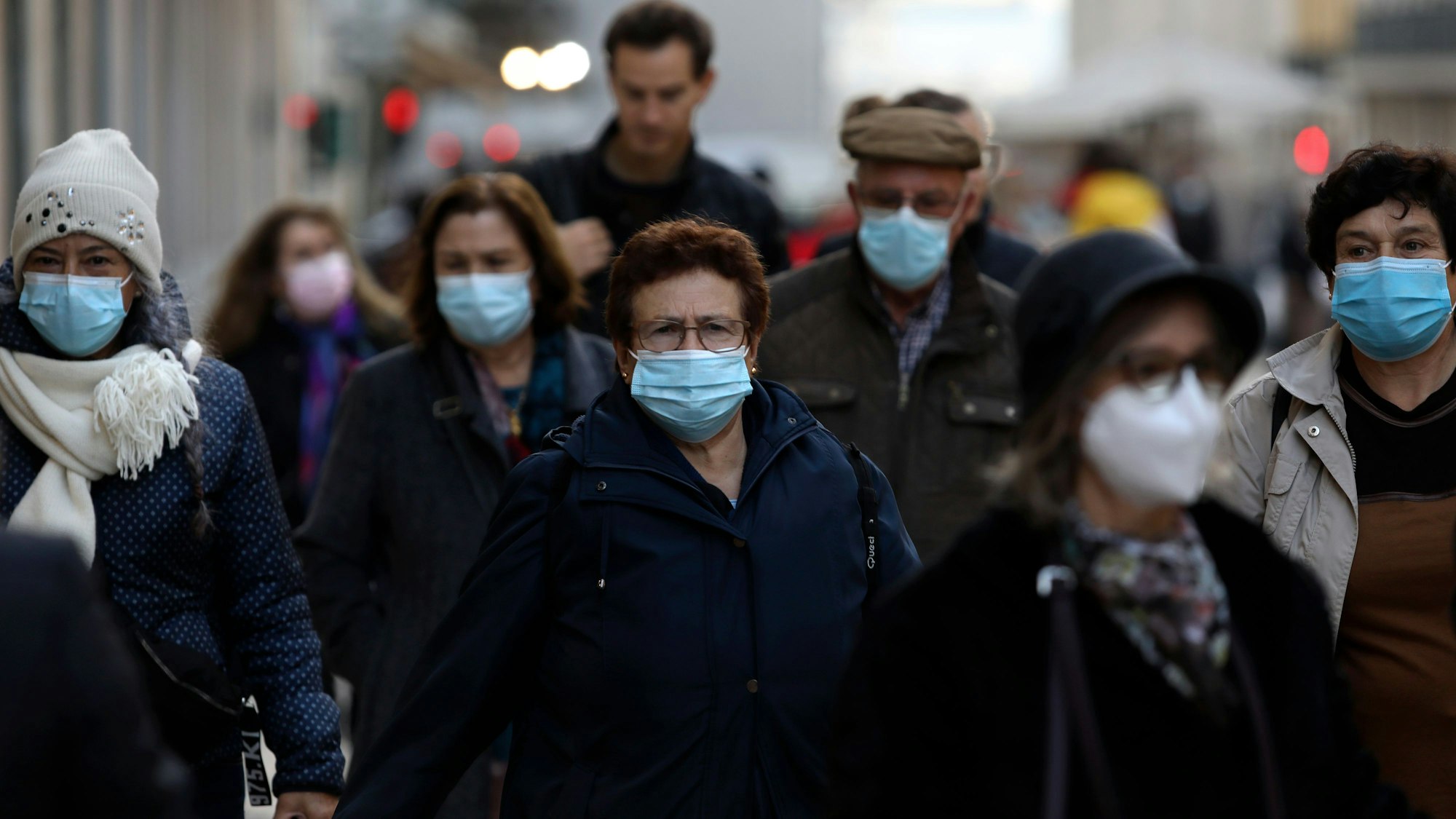 Menschen mit Mund-Nasen-Bedeckung gehen durch die Innenstadt.