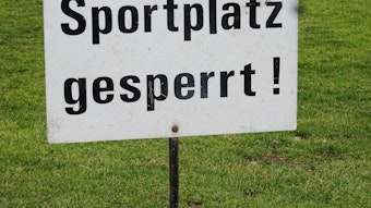 Sportplatz gesperrt! Dieses Symbolfoto stammt vom 19. Februar 2021. Zu sehen ist ein Schild, im Hintergrund ist der Spielfeldrasen.