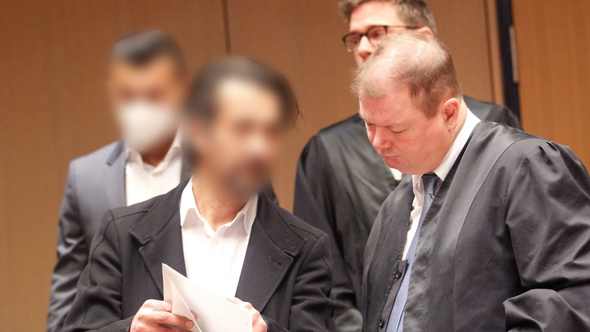 Zwei Männer stehen in Bochum vor Gericht, einer zeigt seinem Verteidiger ein Schriftstück.&nbsp;