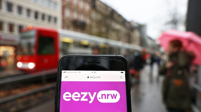 Auf einem Smartphone ist die Startseite von des neuen NRW-Tarifanbieters für Busse und Bahnen, „eezy.nrw“ zu sehen.