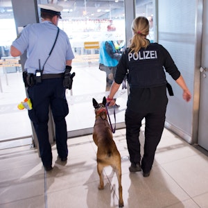 Polizisten mit einem Hund betreten 30.05.2016 den Sicherheitsbereich im Terminal 1 am Flughafen Köln/Bonn (Nordrhein-Westfalen).
